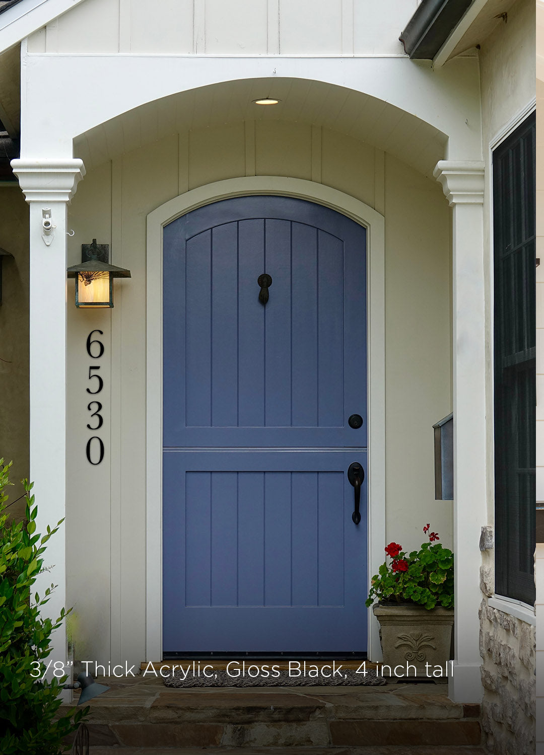 Blue front door of a house with white trim and black 4 inch metal address numbers in a traditional style.