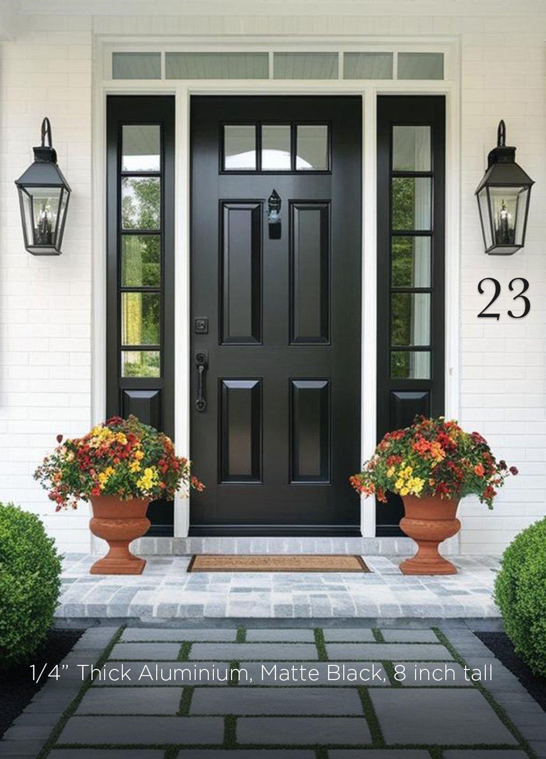 Black front door with glass panels flanked by two lamps and flower pots on a white wall. Black house numbers in a traditional cottage style.