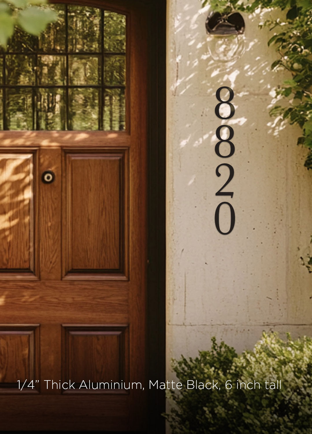 black 8 inch house number '8820' on a white wall next to a wooden door with glass panels.