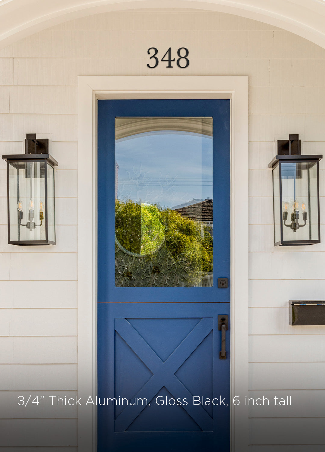 Blue front door with glass panel and 4 inch traditional style black metal house number '348' on a white wall.
