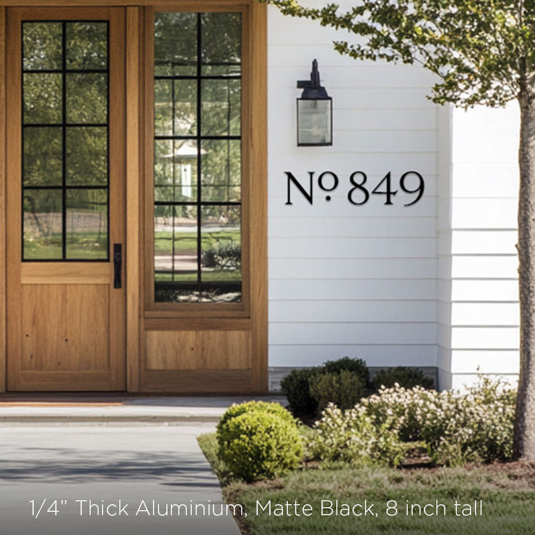 Modern house exterior with wooden door and decorative address numbers in black metal 8 inch tall on white wall