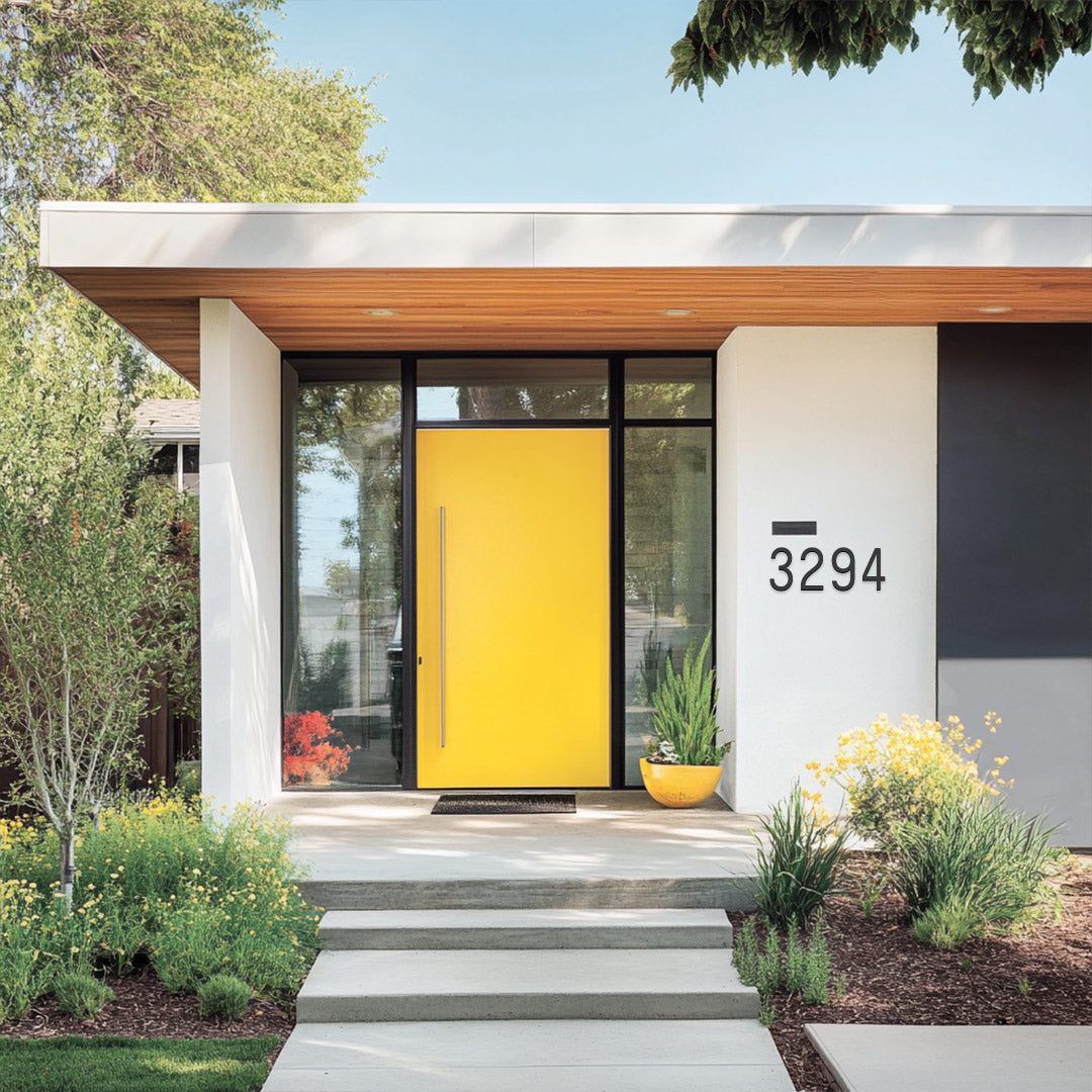 A modern house with a yellow door featuring the number '3294' in a contrasting color.