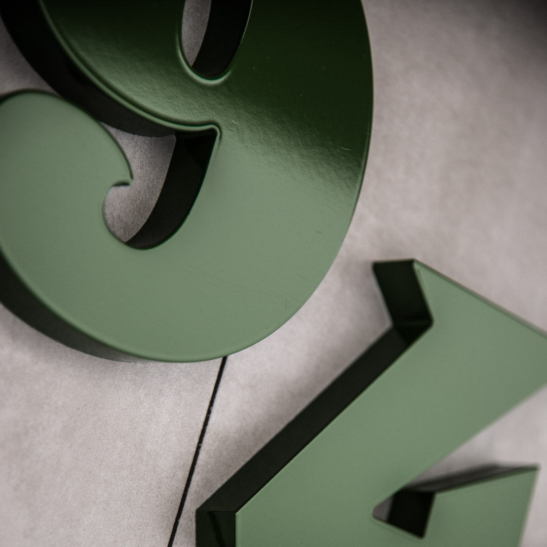 Green house numbers on a concrete house