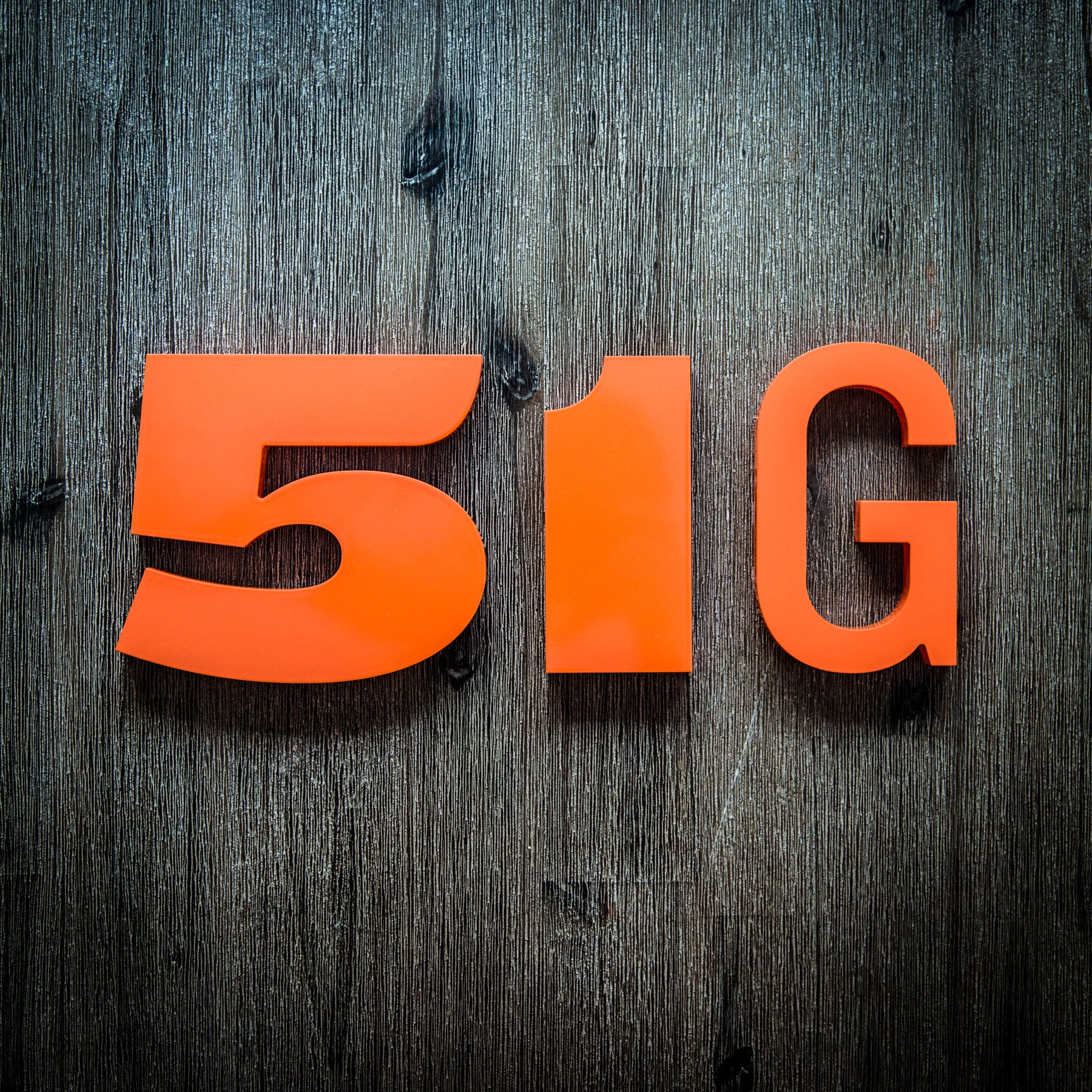 Orange house numbers on a wood background