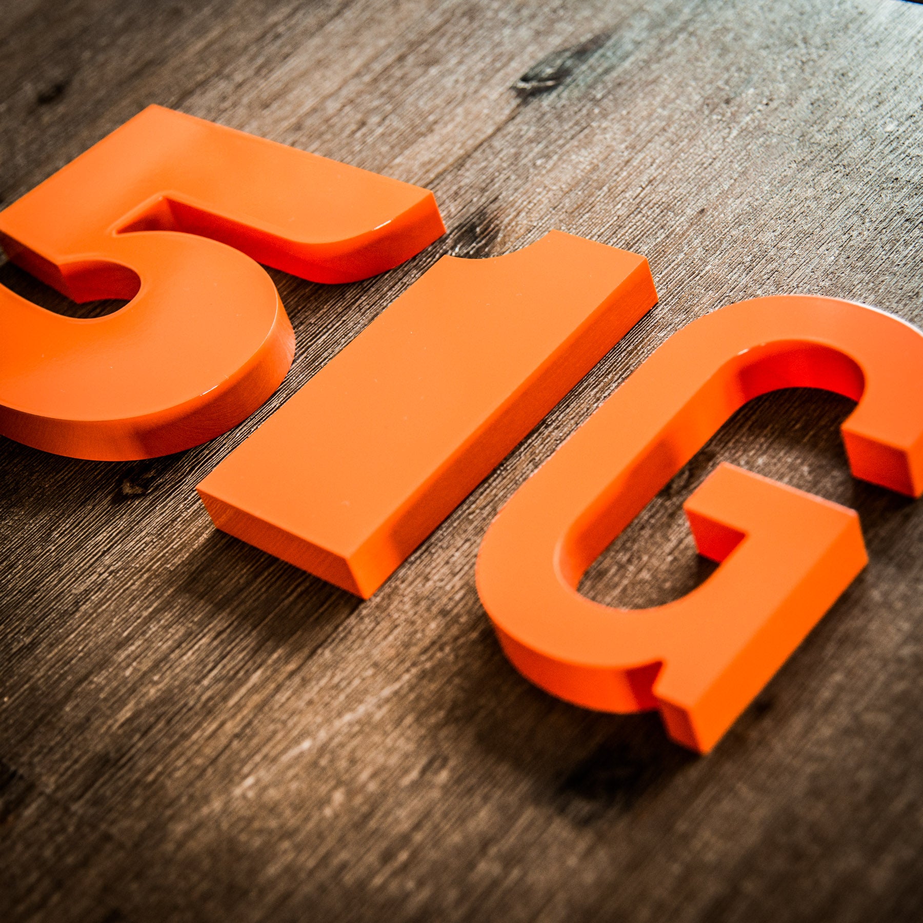 Orange house numbers on a wood background