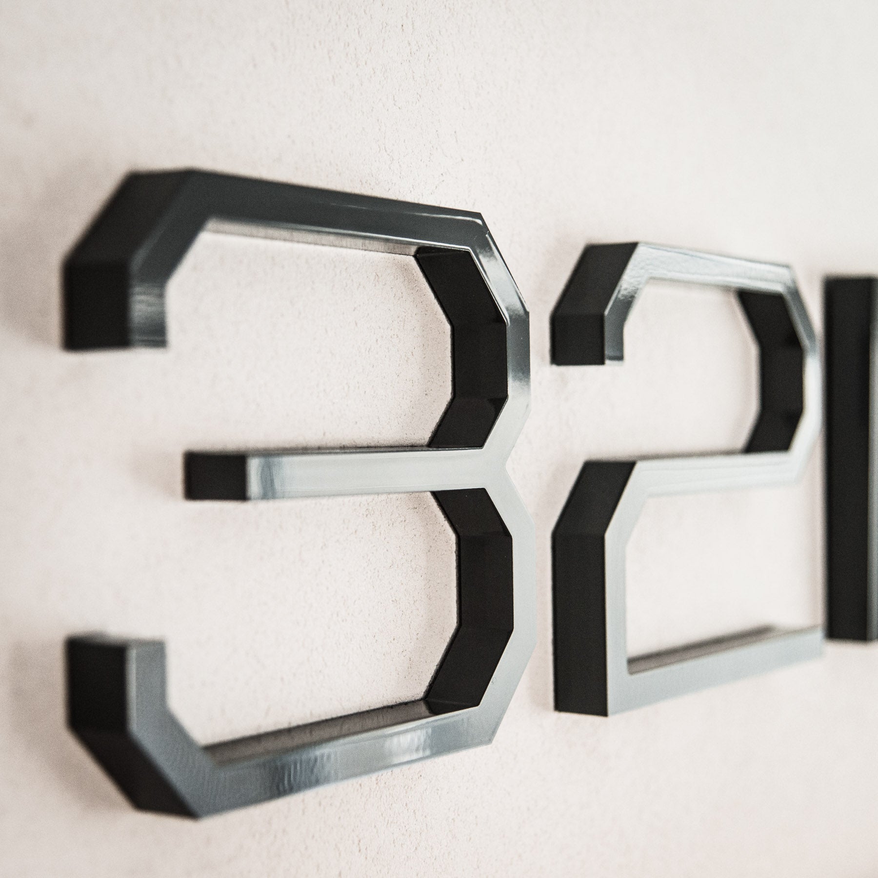 Grey utilitarian house number style in 6 inch on a stucco surface