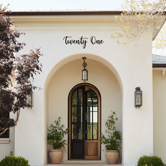 Front entrance of a house with an archway and steps leading to a wooden door, featuring the text 'Twenty One'.
