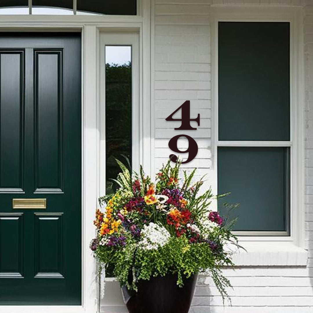 White brick house with green front door black house numbers in a bold style