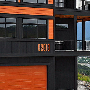 Modern house exterior with orange and black facade. Orange house numbers, 8 inch tall acrylic house numbers