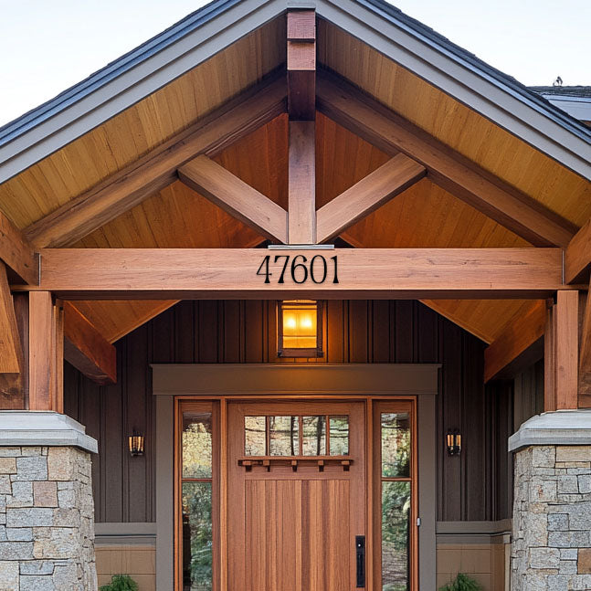 A close-up of a house entrance featuring wooden beams and a dark-colored door, with the number '47601' printed on a wooden beam above the door.