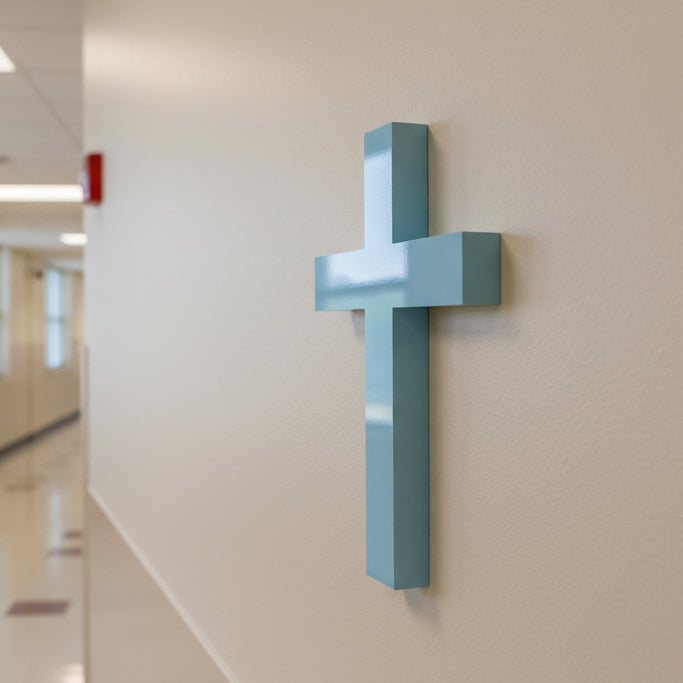 Blue cross on a beige wall in an indoor setting