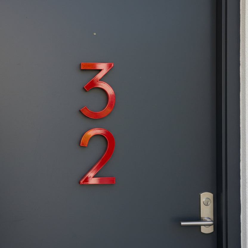 Red door numbers '32' on a dark gray door with a silver handle.