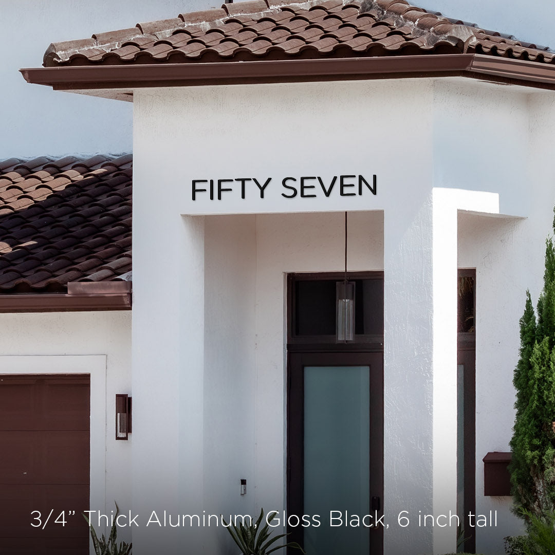 Modern house exterior with 'FIFTY SEVEN' spelled out house numbers on the facade.