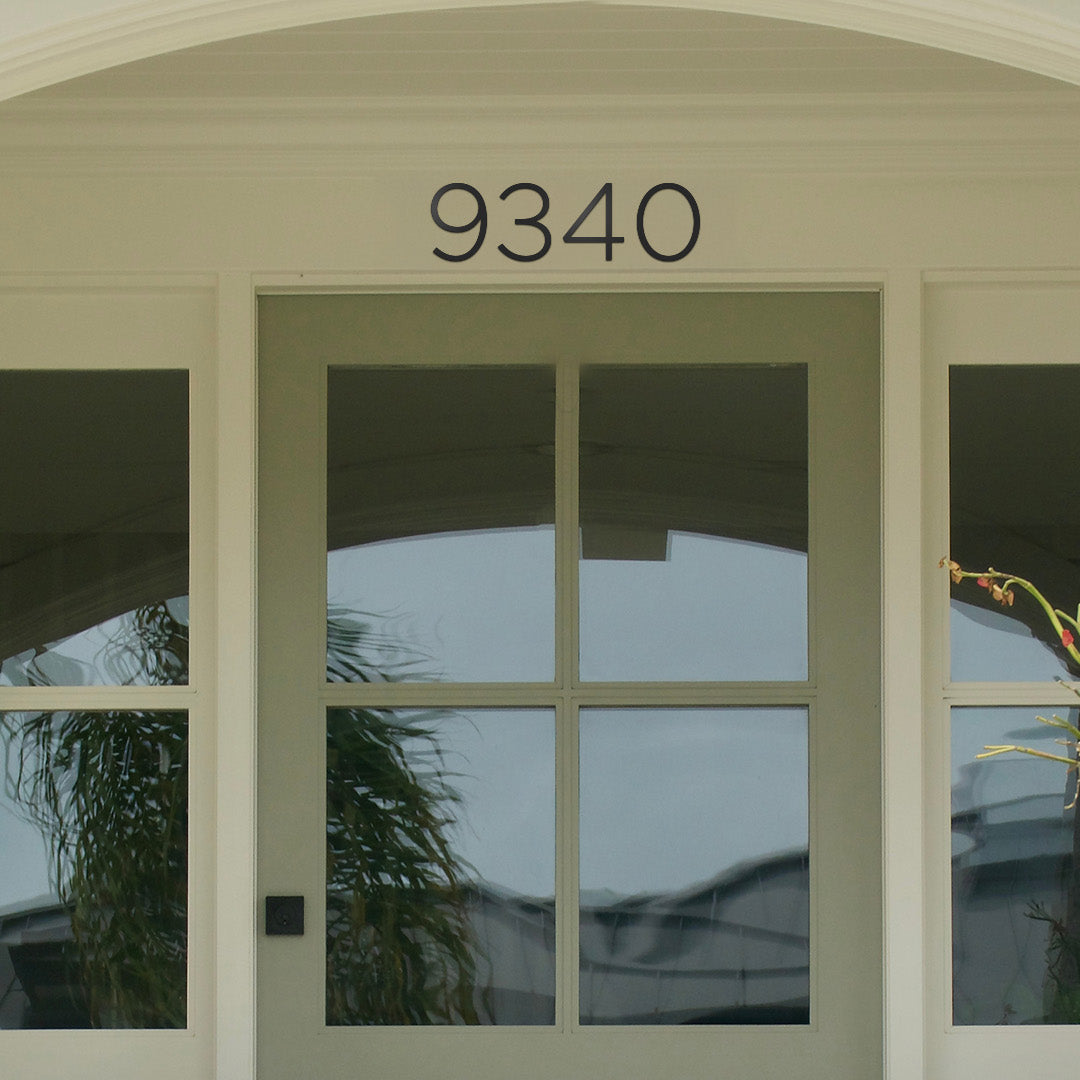 House number '9340' above the door with glass panels. Modern house number style in black metal, 6 inch tall numbers