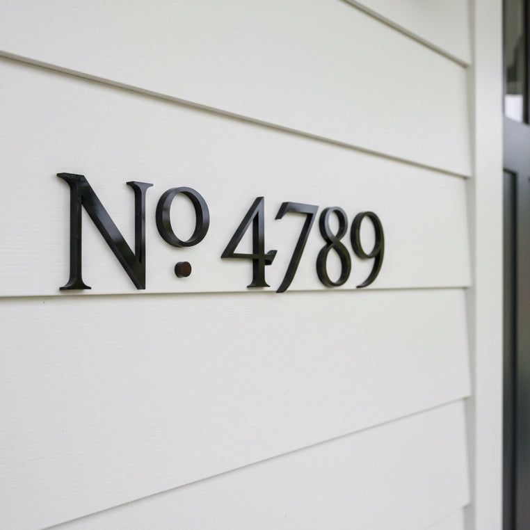 Black House number 'No. 4789' on a white wall