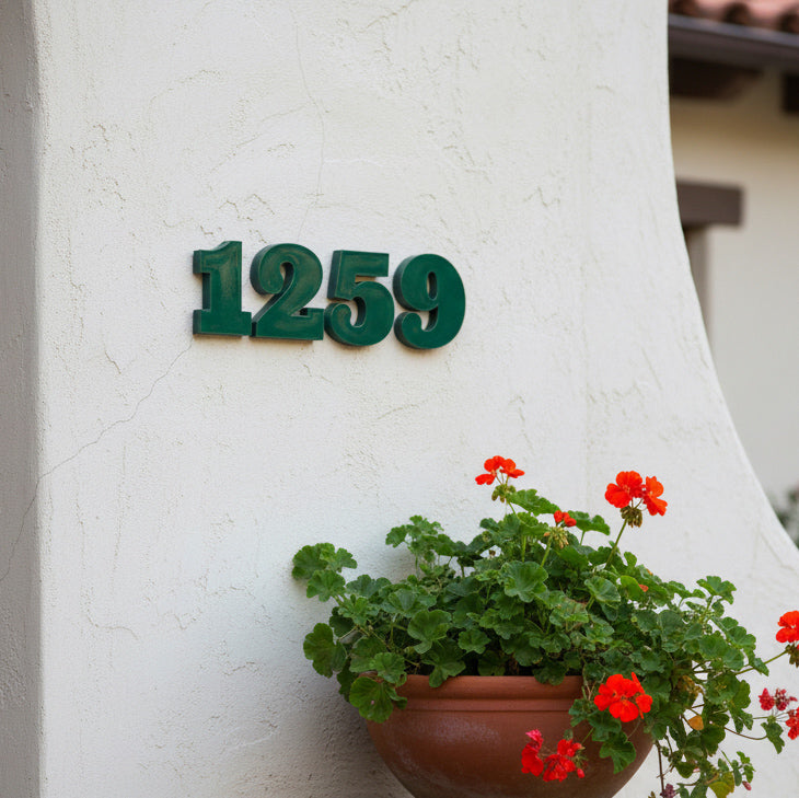green House number '1259' on a white wall with a potted plant below.