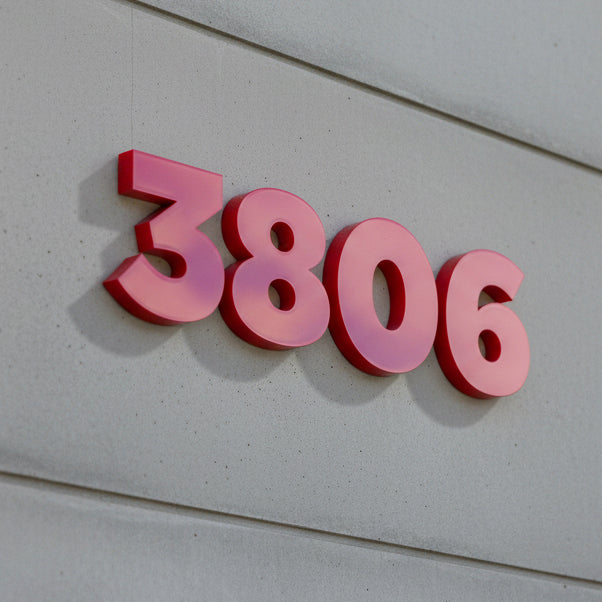 red house numbers '3806' on a light gray wall.