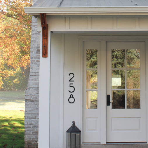 White house entrance with glass doors and house numbers '251'
