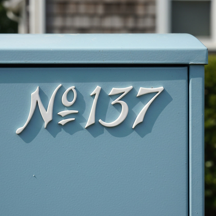 Blue mailbox with white text 'No 137' on a blurred background