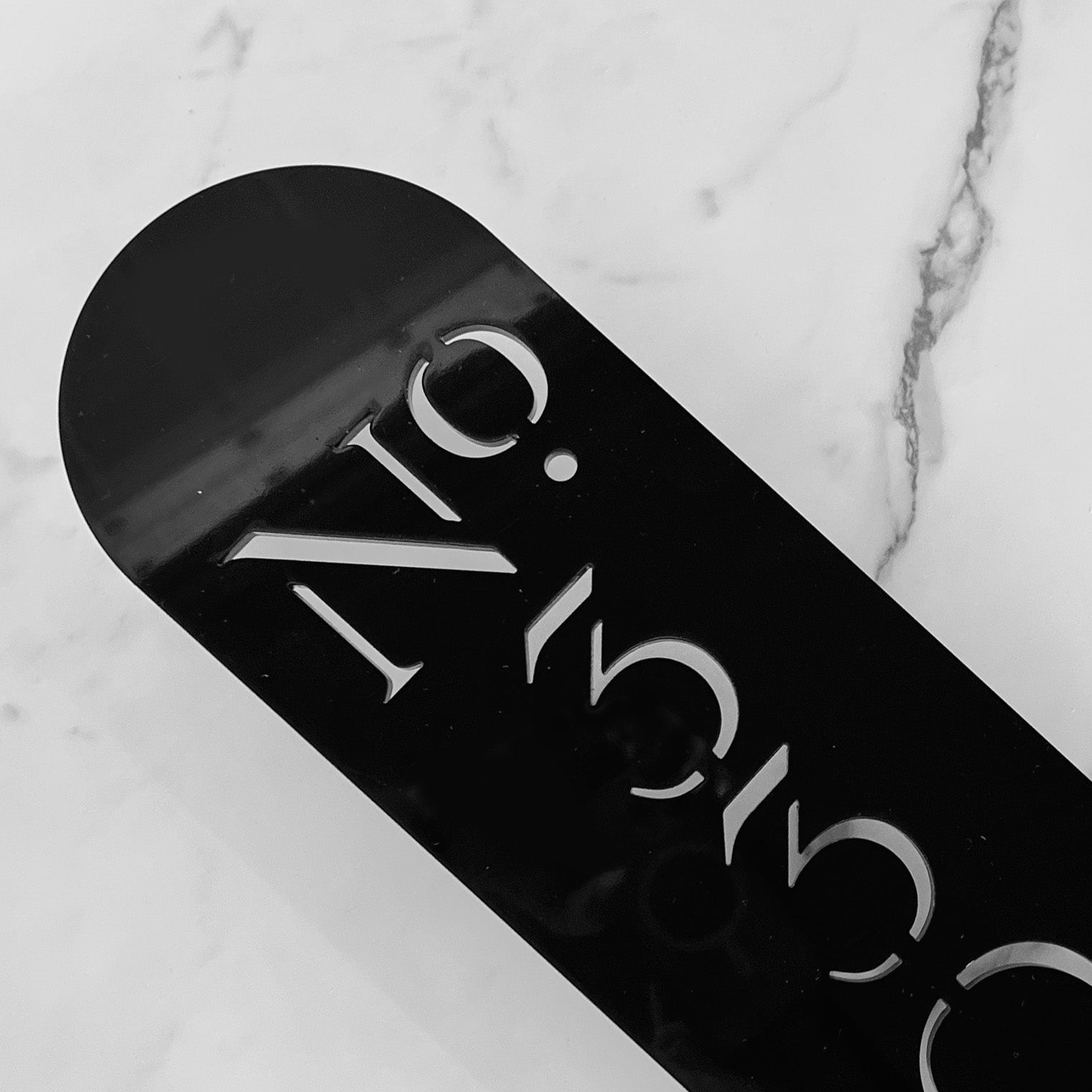A stencil house number sign in black acrylic with no mounting hardware showing