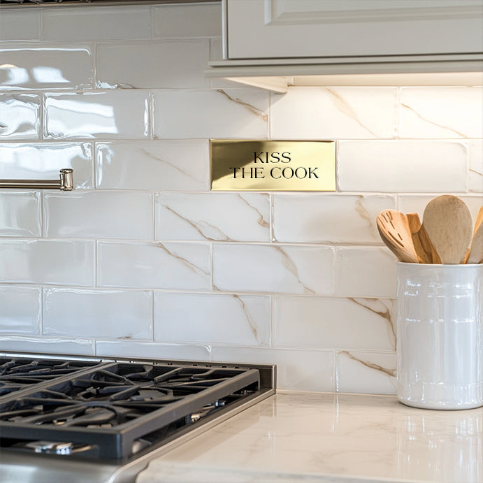 Solid brass accent tile with custom words engraved "kiss the cook"