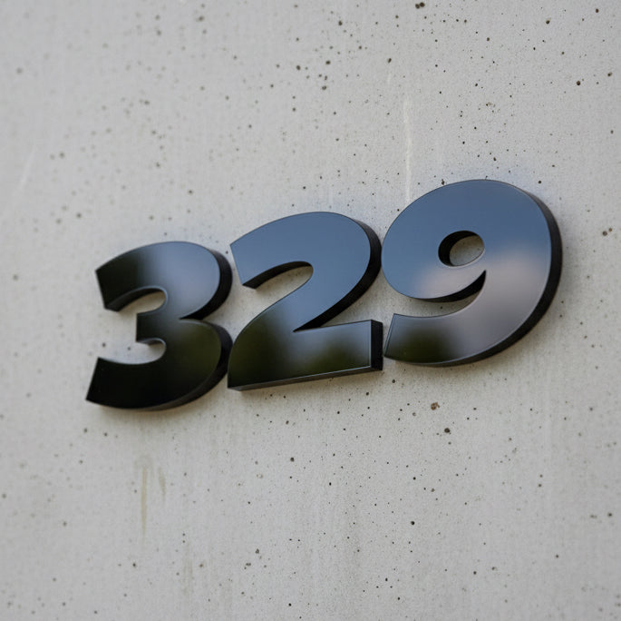 Metallic house number '329' on a textured wall