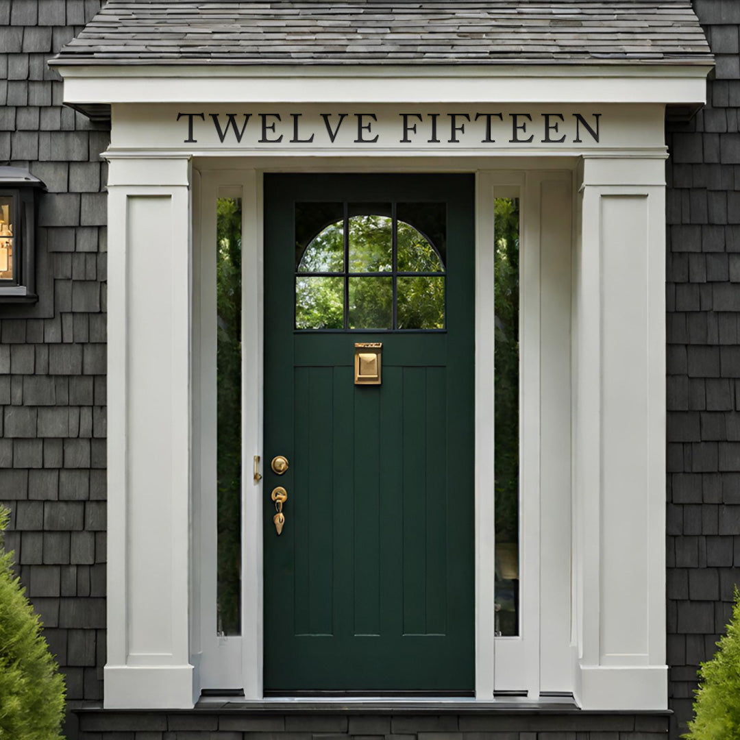 Traditional house with grey shingle shakes with white trim green front door. Spelled out address above front door