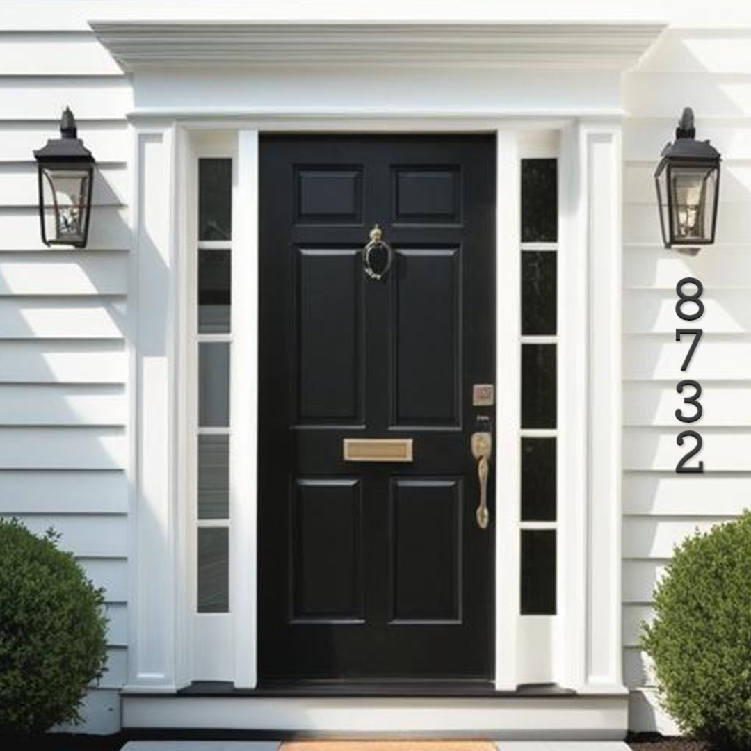 White traditional house with siding and black front door. Black metal house numbers 5 inch