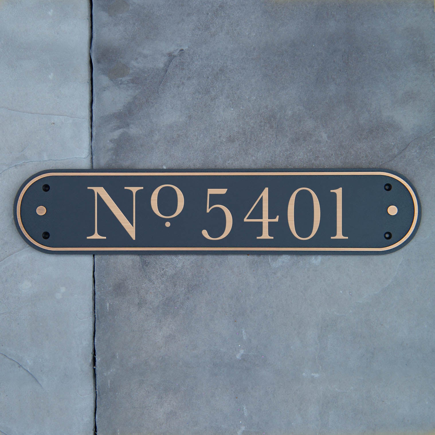 A solid brass address plaque with the number '5401' sandblasted into the surface, mounted on a wall.
