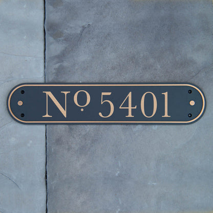 A solid brass address plaque with the number '5401' sandblasted into the surface, mounted on a wall.