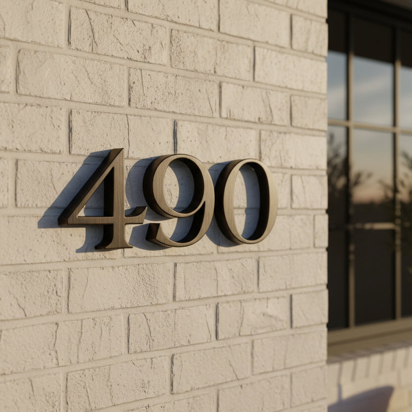 Bronze House numbers '490' on a beige brick wall