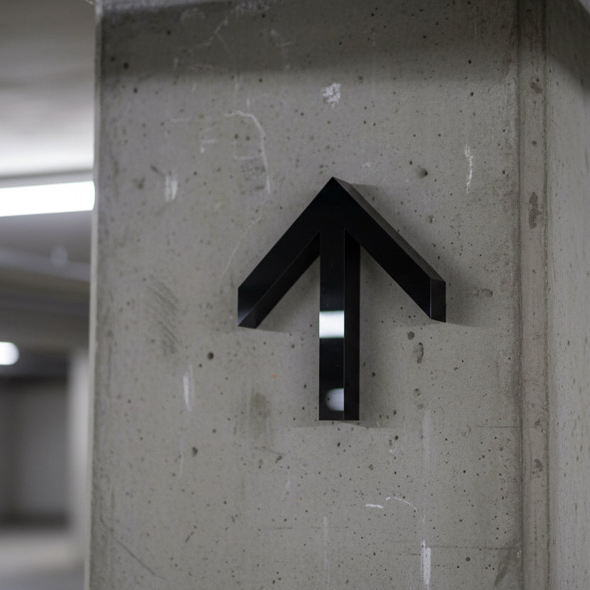 Black arrow symbol on a concrete wall