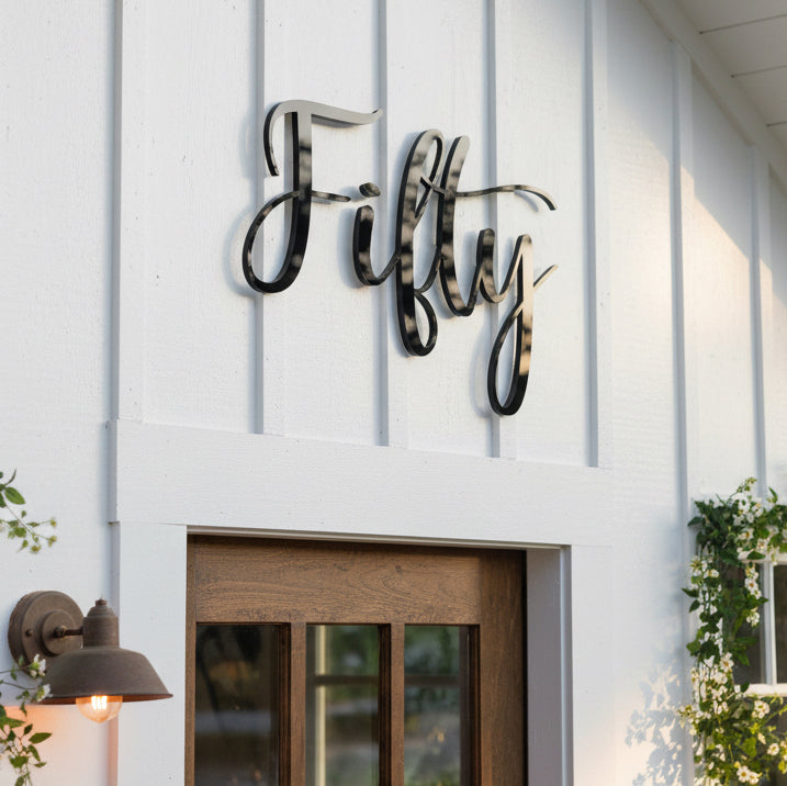 Decorative acrylic sign with 'Fifty' on a white building facade.