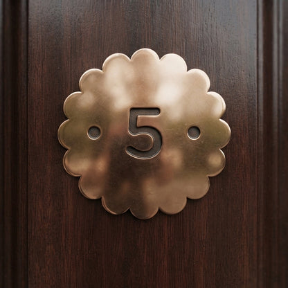 Polished Bronze plaque with a dark bronze number in the center and scalloped edge