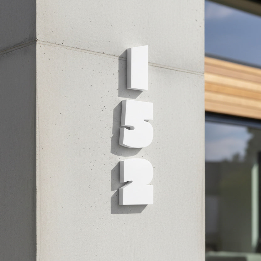 White building number '152' on a concrete wall