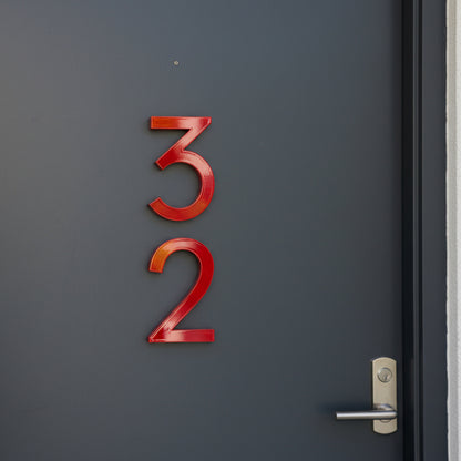 Red door numbers '32' on a dark gray door with a silver handle.