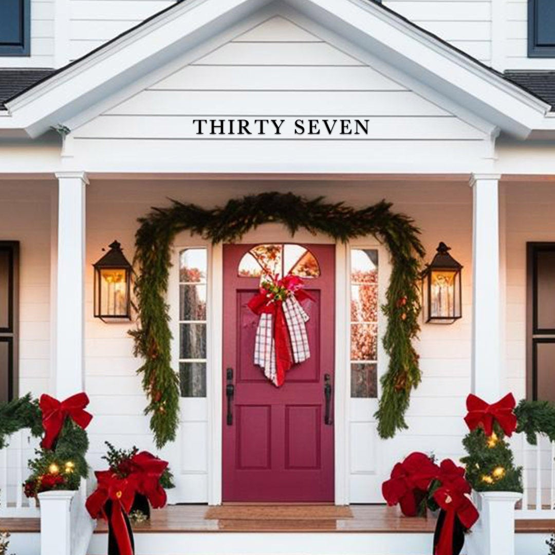 Decorative front door of a house with Christmas wreaths and ribbons, featuring the number 'THIRTY SEVEN'.