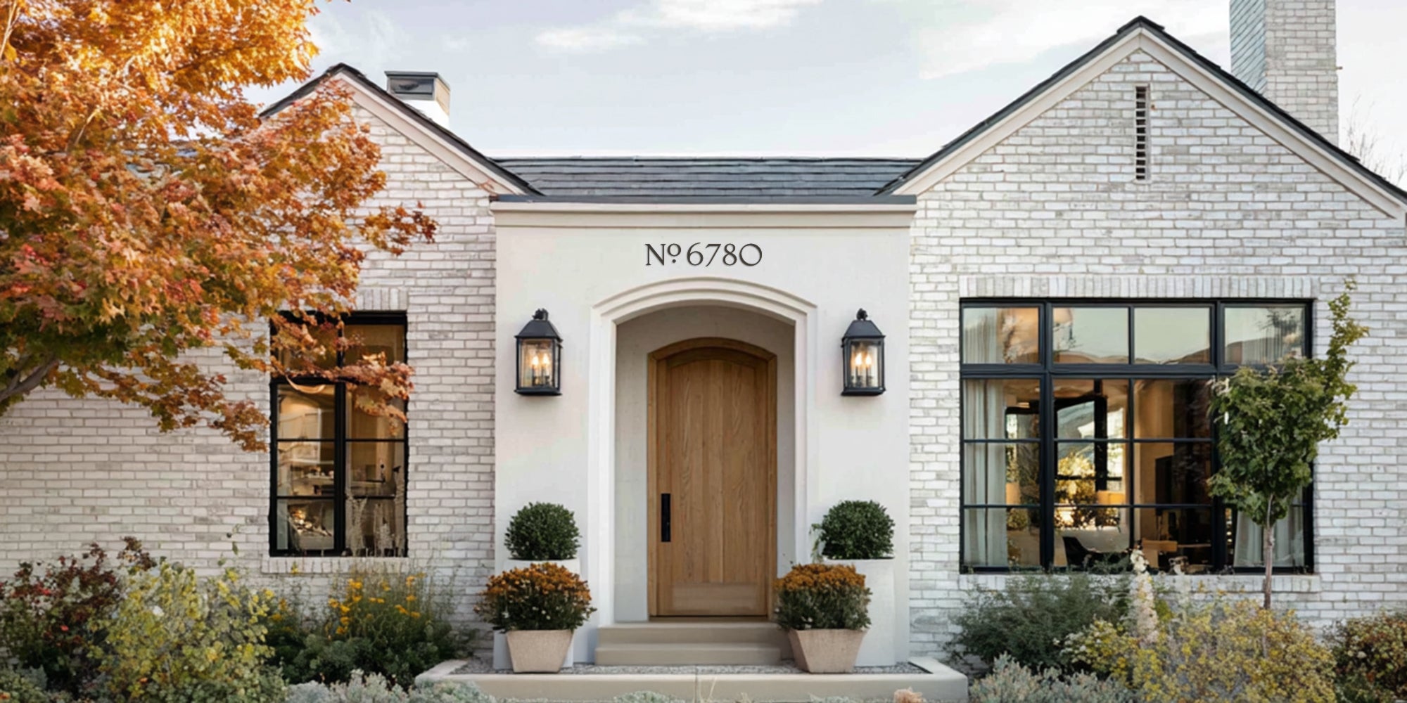 White brick house with black windows and a number '6780' on the facade.