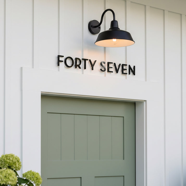 House number 'FORTY SEVEN' displayed on a white wall above a green door.