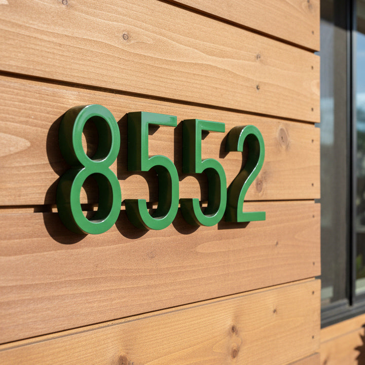 Green house numbers '8552' on a wooden wall