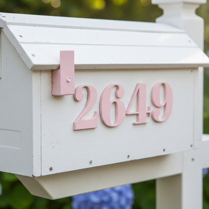White mailbox with pink numbers '2649' against a blurred green background
