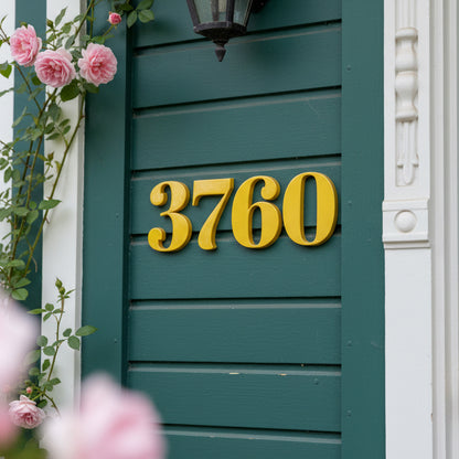 Yellow house numbers '3760' on a green door with pink flowers.