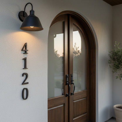 Wooden door with house numbers 4120 on a white wall with a lamp.