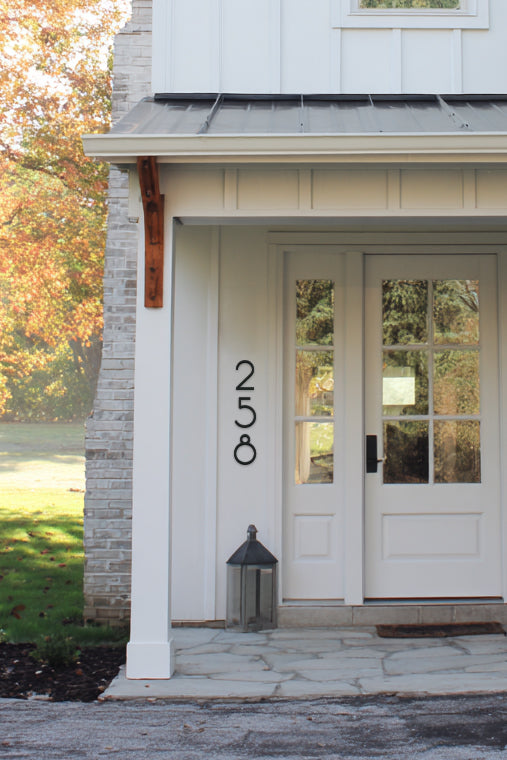 White house entrance with glass doors and house numbers '251'