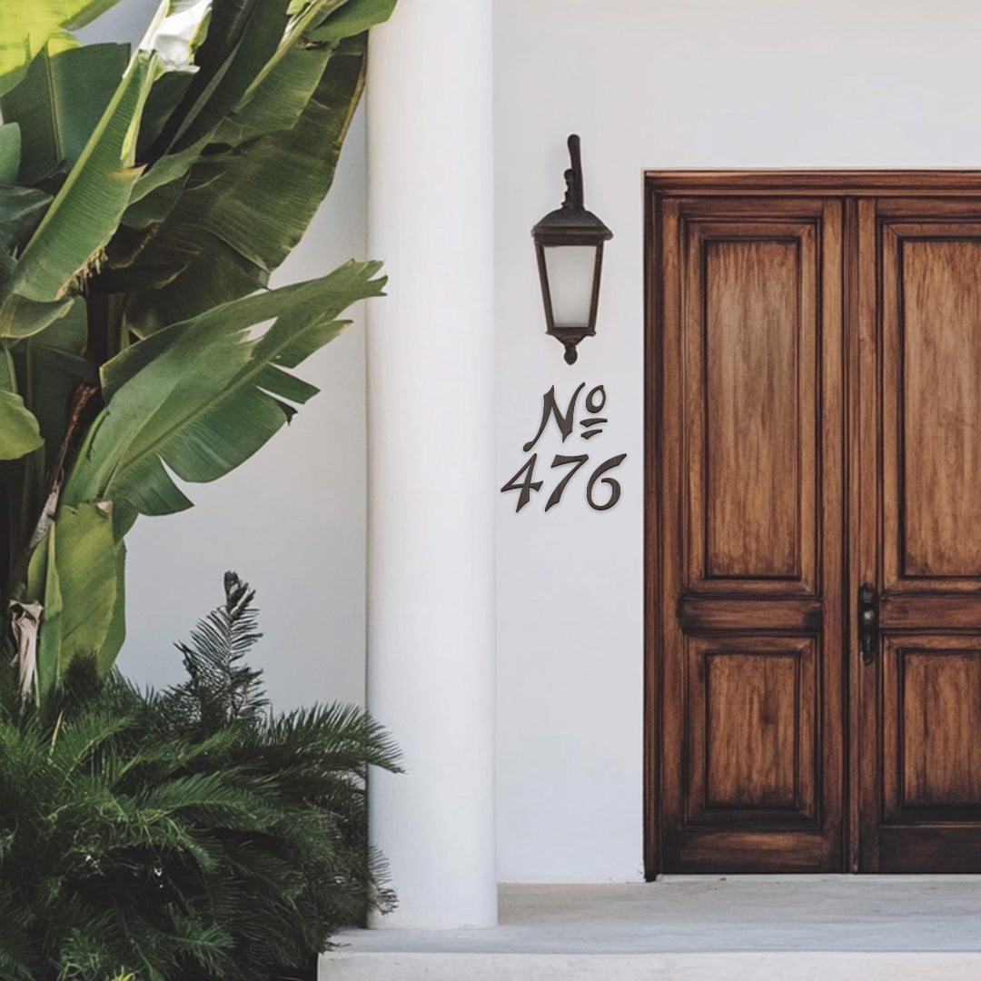 a white stucco beach house with a wood front door and bronze house numbers with "No 476"
