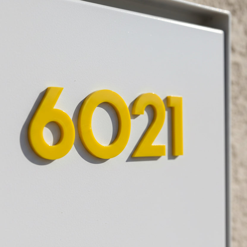 Yellow house numbers '6021' on a white background