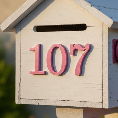 Wooden mailbox with pink house numbers '107'