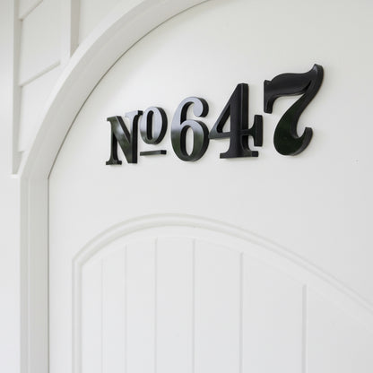 Black house numbers '647' on a white door