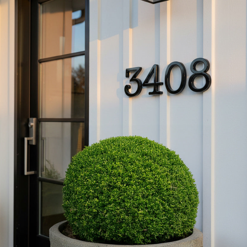 Modern house exterior with black house numbers '3408' and a potted plant.