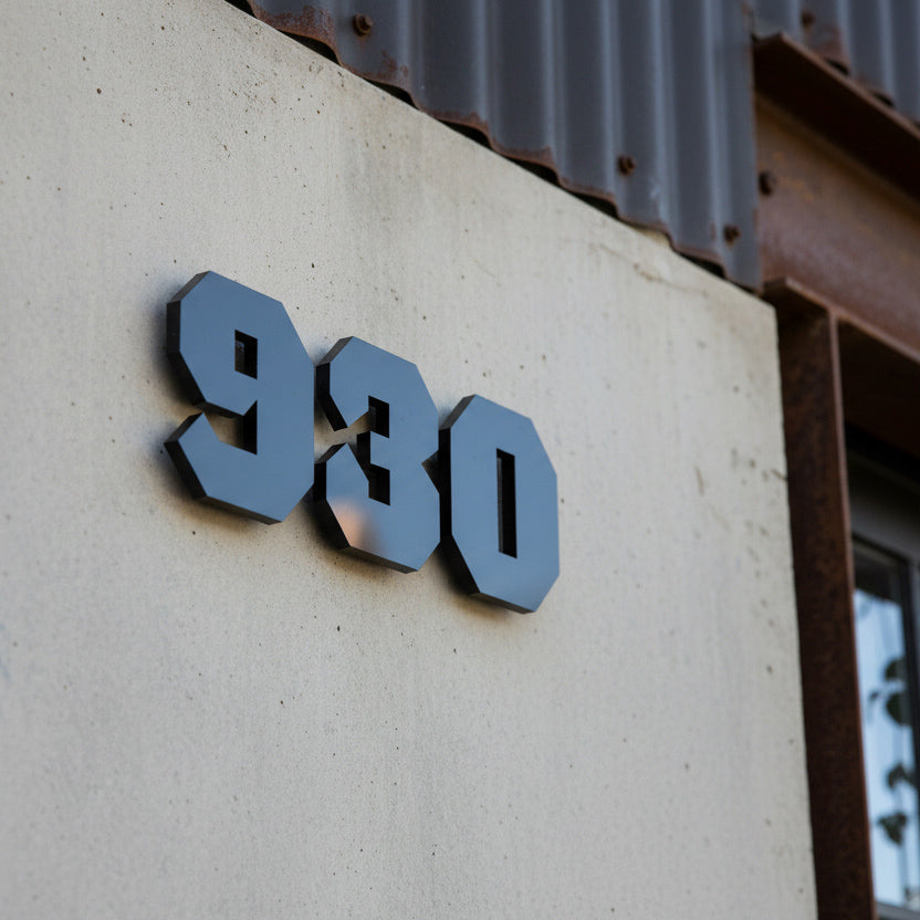 Number '930' on a concrete wall with a rustic background
